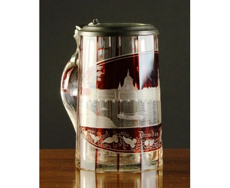 A Ruby Flashed Clear Glass Tankard with hinged pewter mounted lid.  The fluted sides having an oval scenic panel of Dresden d