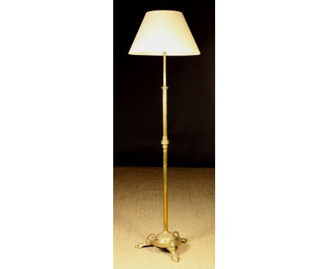 A Brass Standard Lamp with cream shade. The pole stem having a reeded knop and leading down to a circular base with radial re