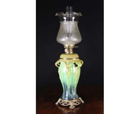 A Tall Art Nouveau Style Oil Lamp having a moulded baluster body dripped in ochre, green and blue glaze on a decoratively cas