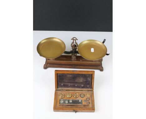 A set of early 20th century balance scales together with a cased set of brass weights. 
