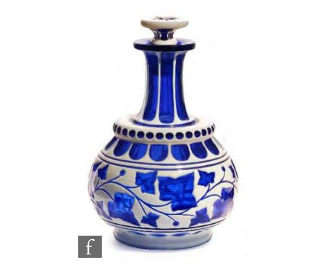 A 19th Century Bohemian glass decanter, circa 1850-1860, of globe and shaft form and cased in opal over cobalt blue and cut w