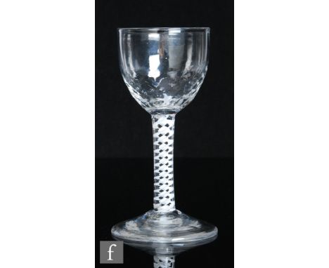 An 18th Century drinking glass, circa 1765, the planished ovoid bowl above a double series opaque twist stem with two spiral 