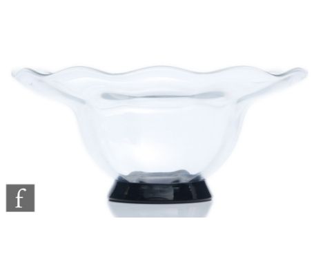 A 1930s Orrefors glass bowl designed by Simon Gate, the circular black foot rising to a fluted bowl with wave rim, engraved s