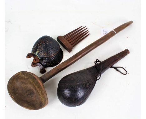 African carved wooden spoon, 50cm long, a pair of ebonised carved body ornaments, a wooden comb, and a leather powder flask, 