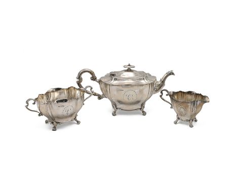 An Edwardian silver three piece tea set, the shaped teapot handle with ivory insulators with each piece standing on paw feet,