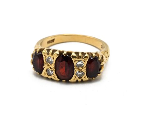 A 18ct gold diamond and three stone garnet gypsy ring, stamped "18ct", finger size M, 5.40 grams.(J)