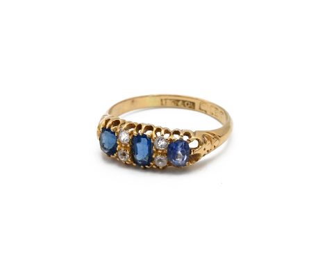 A Victorian 18ct yellow gold sapphire and diamond ring, set with three oval mixed cut sapphires and four small old cut diamon