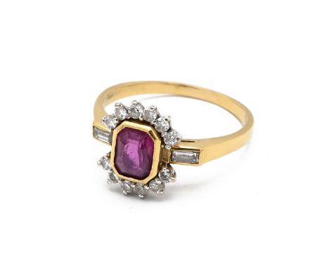 An 18ct gold, diamond and ruby dress cluster ring, the central ruby of cushion form and surrounded by ten brilliant cut diamo