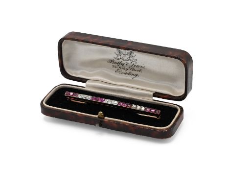 An Edwardian century gold, ruby and diamond line bar brooch, set with tweleve rubies and nine diamonds, 6.4cm long, 5.97 gram