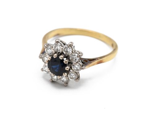 An 18ct yellow gold sapphire and diamond cluster ring, set with a round cut sapphire within a border of ten round brilliant c