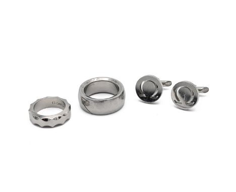 An Omega titanium Aqua ring, finger size P 1/2, along with a Omega stainless steel ring, finger size V and a pair of Omega cu