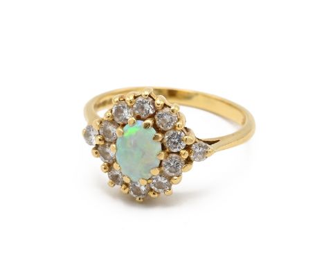 An 18ct gold, diamond and opal cluster ring, the central opal surrounded by eleven brilliant cut diamonds and with two diamon