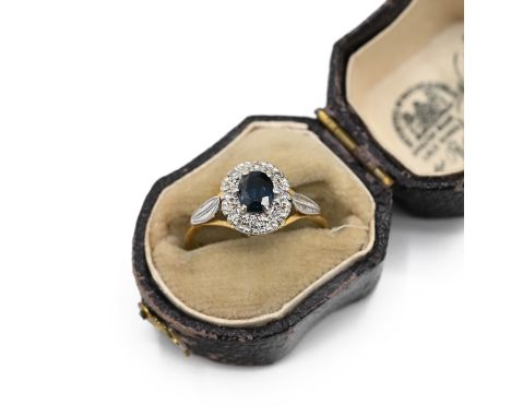 An 18ct gold and sapphire cluster ring, the oval sapphire surround by brilliant cut diamonds, finger size M, 3.13 grams. (J)