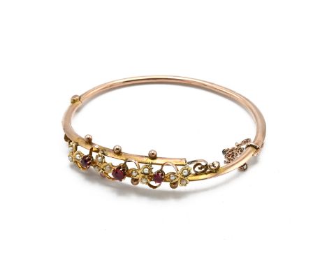 A Victorian-style seed pearl and ruby bangle, set with three central rubies and seed pearl three-leaf plants, 6.75 grams, 6.2
