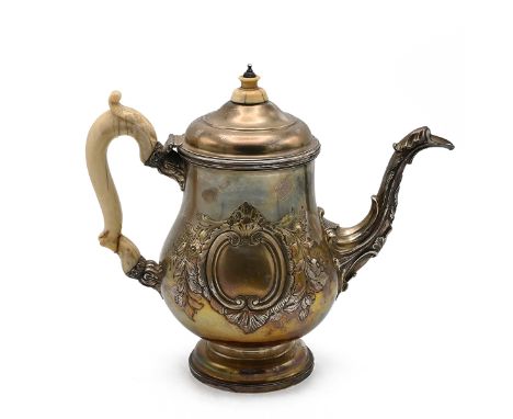 A George III Silver coffee pot, with foliage to the main body and spout and having a vacant cartouche, with an ivory handle a