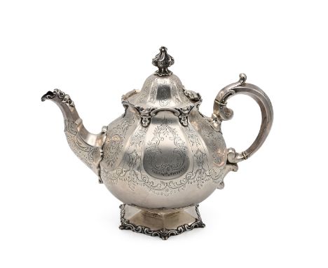 A Victorian silver teapot, of globular form with engraved foliage throughout, shaped finial and ivory spacers to the handle. 