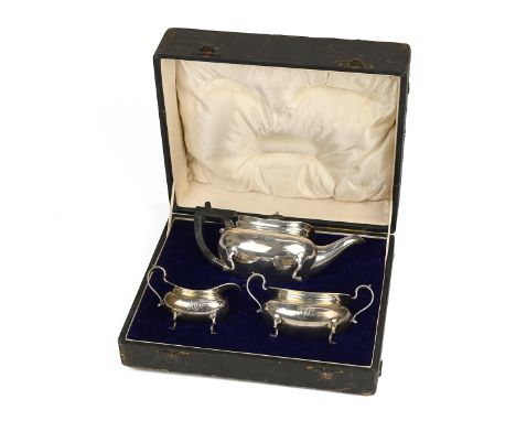 A George V silver three piece tea set, each piece with outstretched legs, the teapot with an ebony handle, in a fitted case, 