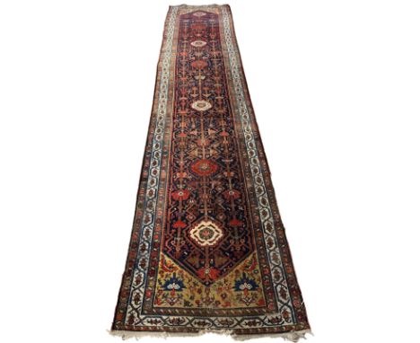 A NORTH WEST PERSIAN RUNNER 20th century, with all over stylised floral patternation, 490cm x 106cm 