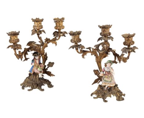 A PAIR OF CONTINENTAL GILT BRONZE AND PORCELAIN MOUNTED THREE LIGHT CANDELABRA IN ROCOCO REVIVAL TASTE mid 19th century, the 
