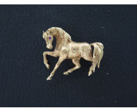 An 18ct yellow gold brooch of a horse set with ruby eyes - approx 3cm - weight approx 7.5grams 