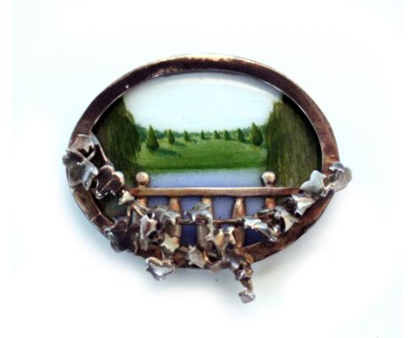 A MODERN SILVER BROOCH of oval form with inset enamel panel with a far reaching pastoral view, decorated with ivy leaves 4cm 