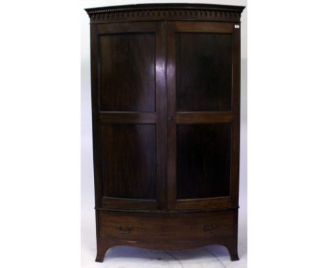 A MAHOGANY BOW FRONTED WARDROBE with panel doors over a single long drawer and standing on splaying bracket feet, 127cm wide 