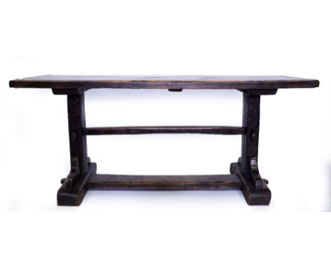 AN OAK REFECTORY TYPE TABLE the plank top with cleated ends and standing on end supports united by stretchers, 176cm wide x 6