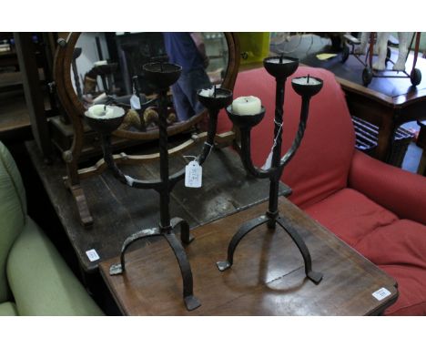 A PAIR OF WROUGHT IRON THREE LIGHT CANDELABRAon tripod bases, each 46cm high