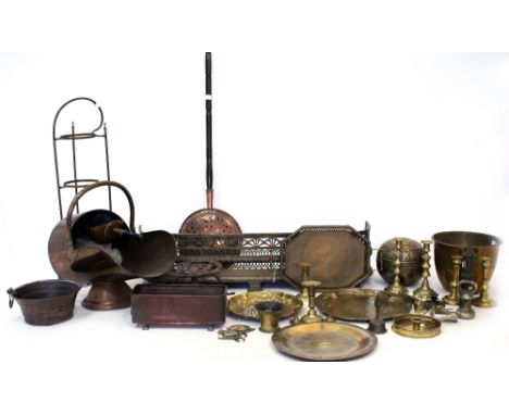 A QUANTITY OF BRASS AND COPPERWARE to include a pierced brass fender, a copper helmet shaped coal scuttle and a pair of candl