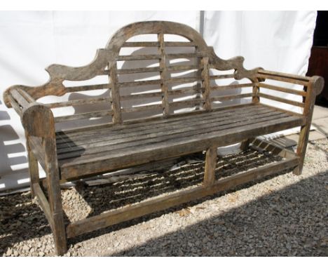 A LUTYENS STYLE TEAK GARDEN BENCH with a shaped back and slatted seats by Lindsey, 195cm wide x 60cm deep.