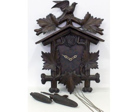 A 20TH CENTURY BLACK FOREST STYLE CARVED CUCKOO CLOCK with bird pediment, weights and pendulum, the clock face measures 11cm 