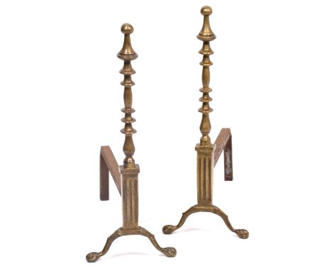 A PAIR OF 20TH CENTURY BRASS FIRE DOGS with finial, on knob stem standing on ball and claw feet, 53cm high x 42.5cm deep (a p