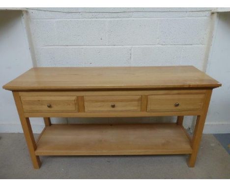 A contemporary light oak serving table of three drawers with an undertier.