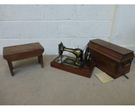 An oak cased Singer sewing machine and a wooden stool.