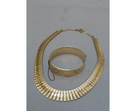 A 9ct gold and bronze core bracelet with engine turned decoration and an Egyptian style gilt necklace.