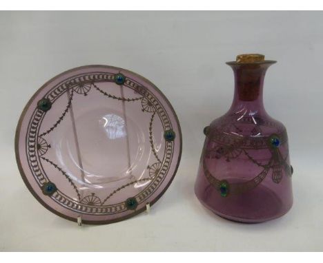 An Art Nouveau amethyst glass carafe over laid with silver and peacock feather eyes with a matching bowl.