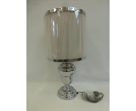 A large contemporary baluster table lamp with white pleated shade.