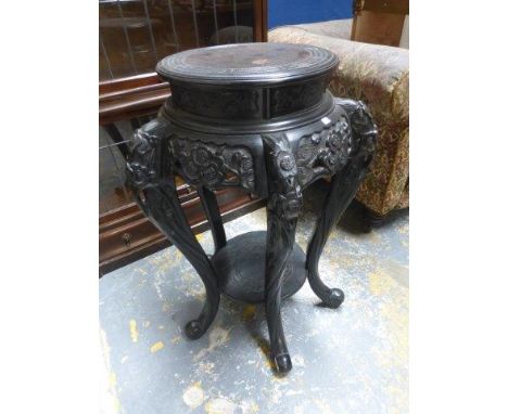 A carved ebonised plant/lamp stand raised on five carved cabriole supports.