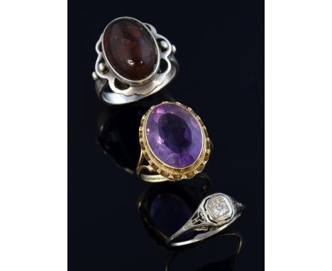  An Edwardian diamond set ring in unmarked white metal, inset with old cut stone,and  two vintage rings, an amethyst set gold