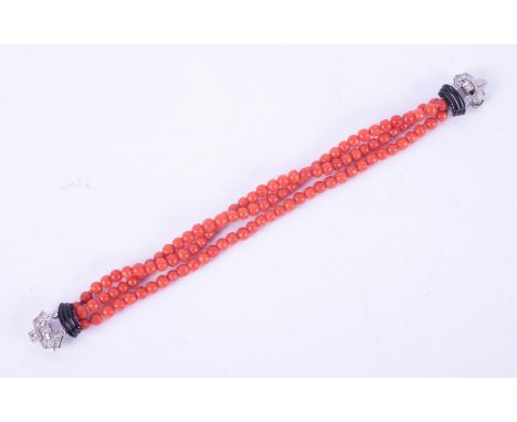 An Art Deco three strand coral &amp; onyx bracelet with a decorative white gold diamond set clasp, the coral beads measure ap