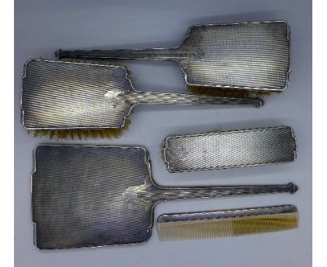 A five piece silver Art Deco mirror, brush and comb set, Birmingham 1935