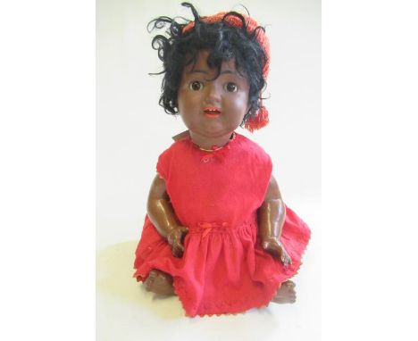 A Kammer &amp; Reinhardt bisque socket head mulatto character doll, with brown glass sleeping eyes, open mouth, teeth, sprung