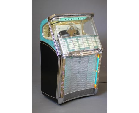 A Wurlitzer hi-fi juke box, with chrome metal mounts, button selectors, glazed top revealing interior mechanism, illuminated 