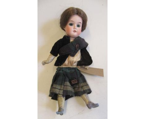 A Gebruder Knoch bisque socket head scotch doll, with green glass fixed eyes, open mouth, teeth, brown wig, five piece compos