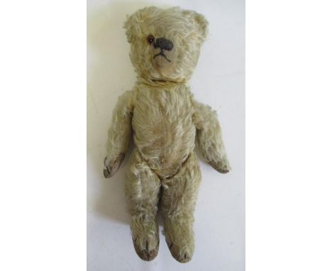 A pre-war teddy, with sewn nose, one amber eye, cloth pads, light orange plush and swivel joints, 14" long (Est. plus 21% pre