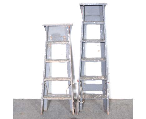 Two painted wooden step ladders.
