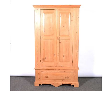 Modern pine double wardrobe, moulded cornice, two panelled doors enclosing a hanging rail, drawer base, bracket feet, width 1