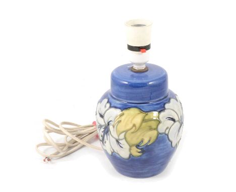 Moorcroft Pottery, a 'Hibiscus' pattern lamp base, ginger jar with integral cover form, pale blue flowerheads against a navy 