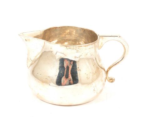 An Irish silver milk jug, John Smyth, Dublin 1902, plain polished finish, scroll handle, 9.5cm, 15.6oz.SALEROOM NOTICE: VAT i