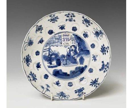 A Chinese porcelain blue and white lobed dish, Kangxi period with six character mark, (1662-1722), decorated with figures and